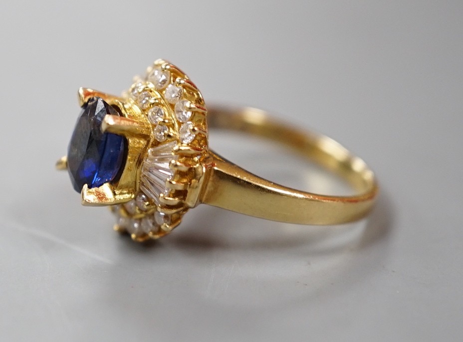 A modern 750 yellow metal, sapphire and diamond set oval cluster ring, size H, gross weight 4.6 grams.